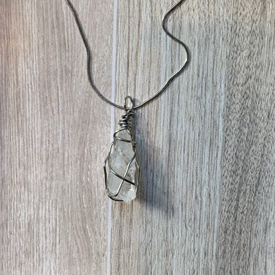 Necklace with a clear crystal pendant on a wooden surface
