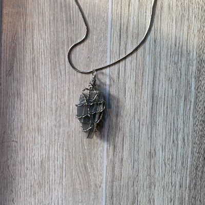 Necklace with a gray rough stone pendant with wire wrapping 