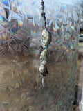 Three raw rainbow moonstone crystals wrapped in wire forming a hanging decorative charm