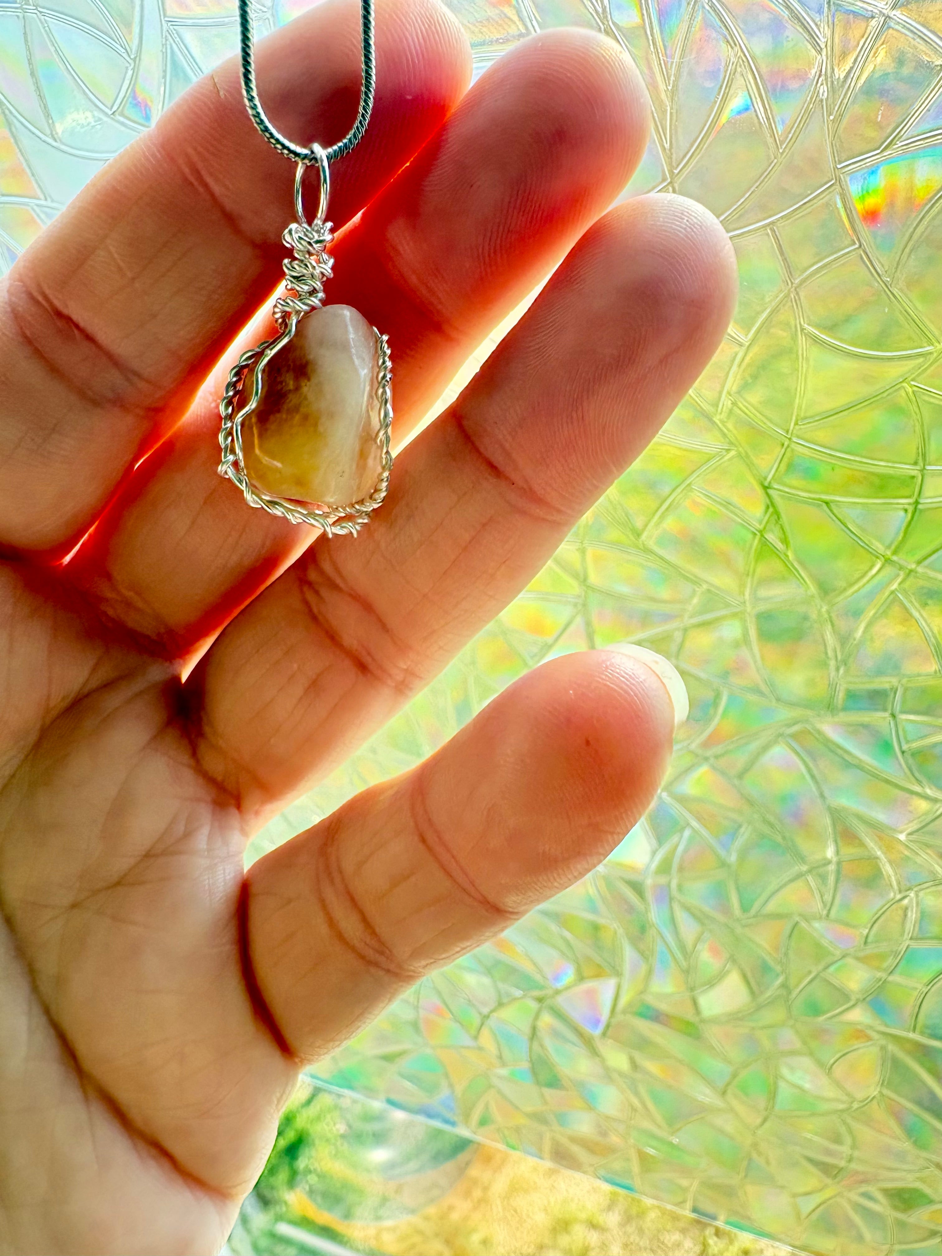 Hand holding a stone pendant